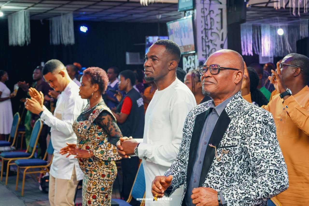 The congregation standing together in prayer and worship