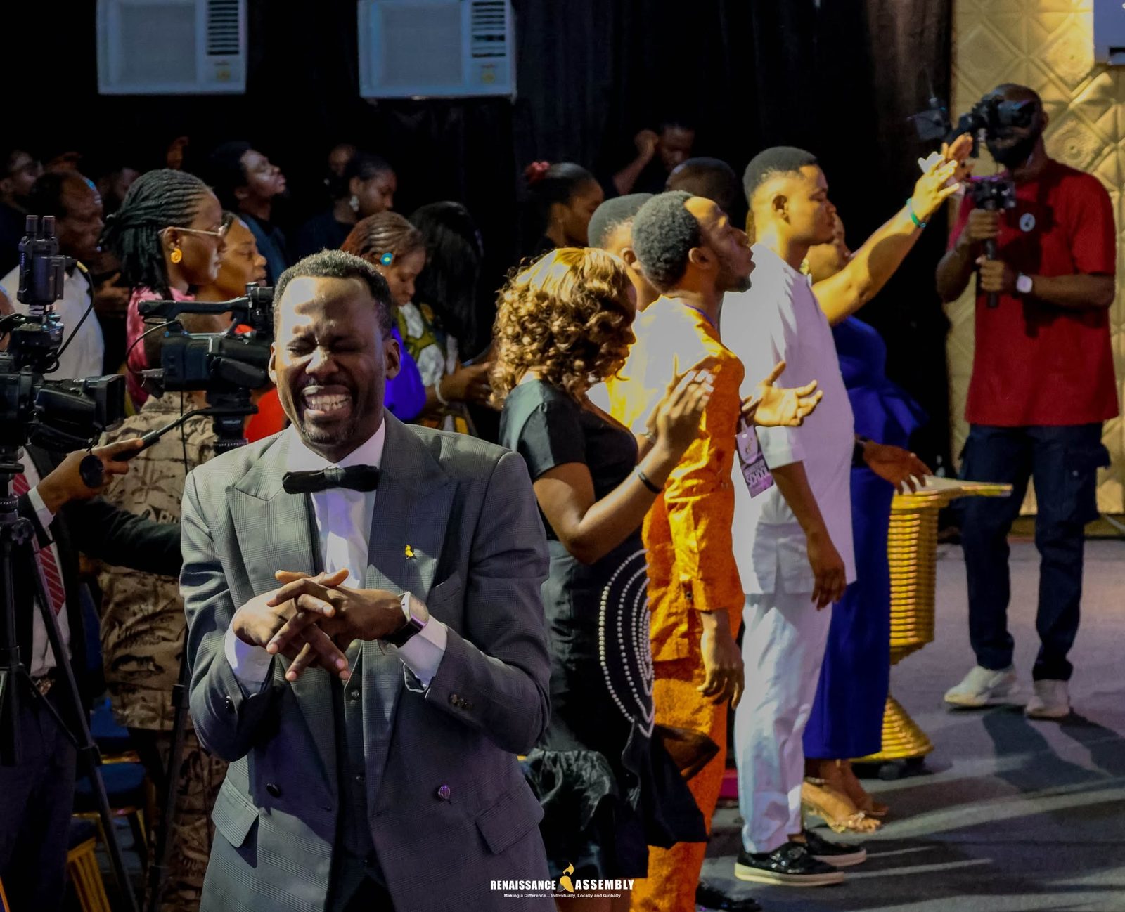 A minister in a moment of worship, surrounded by the congregation